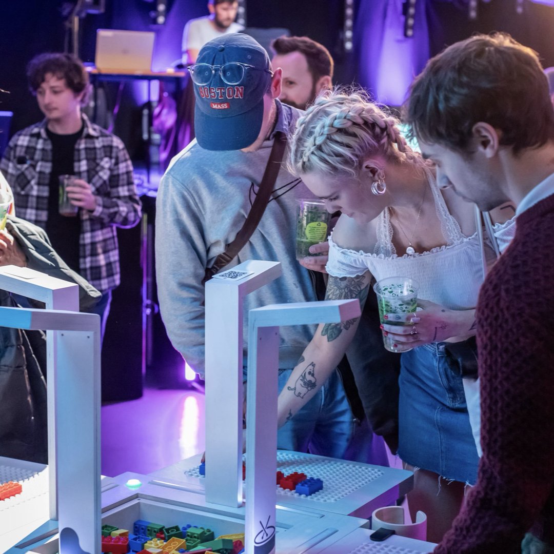 Several people place bricks on the BeatBlocks Live installation.
