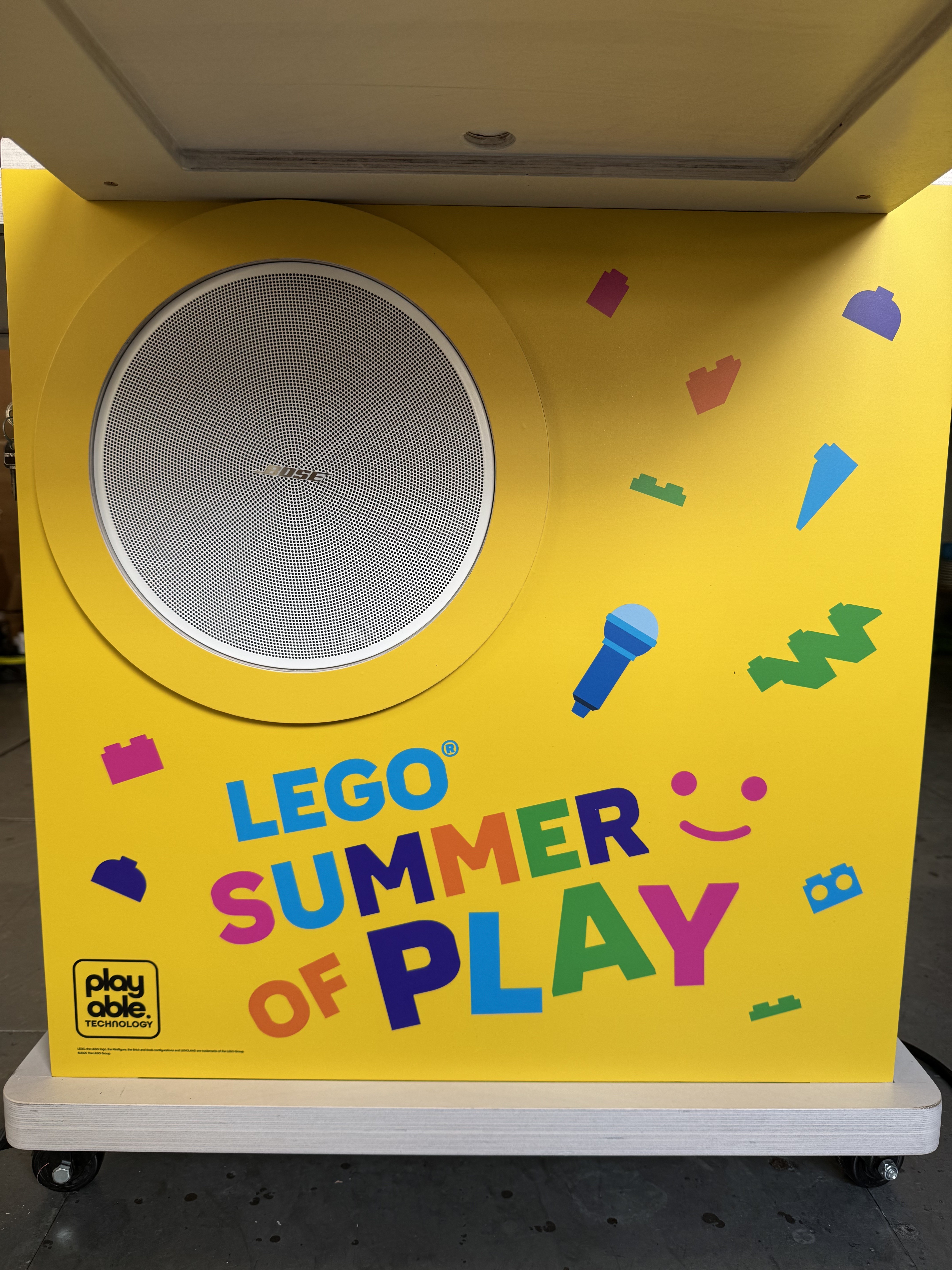 The yellow side of a BeatBricks unit, with a built-in Bose speaker and the LEGO Summer of Play logo.
