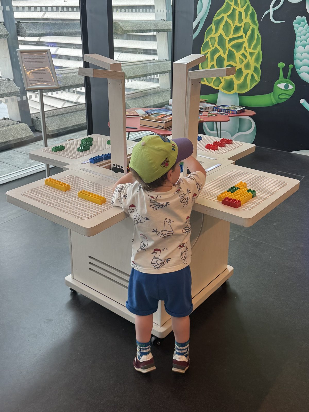 A child plays at the BeatBlocks Live unit in V&A Dundee's Robertson Studio, its four brick baseplates and camera columns visible.