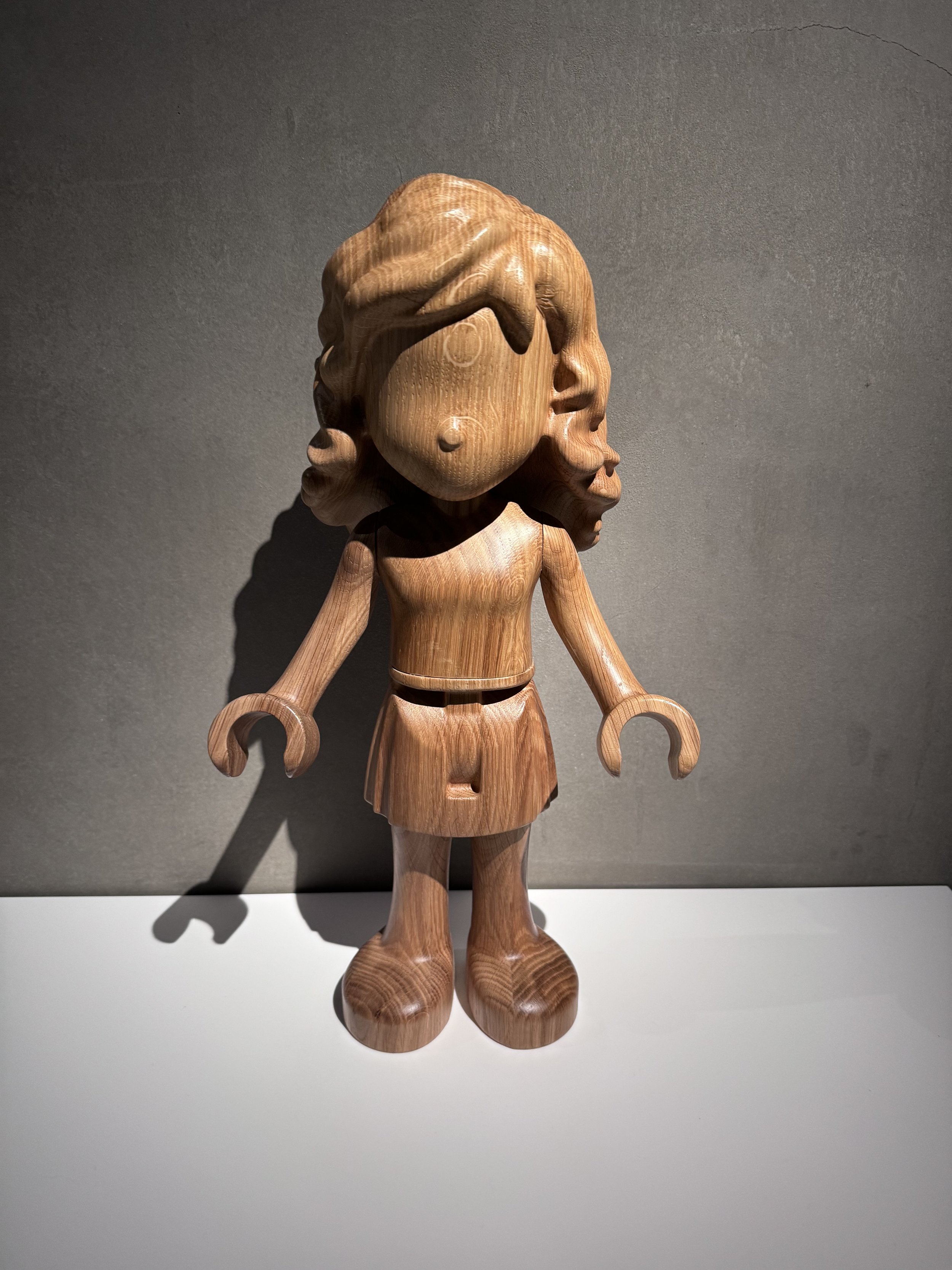 A tactile carved wooden LEGO Friends minifigure inside the LEGO House exhibition.