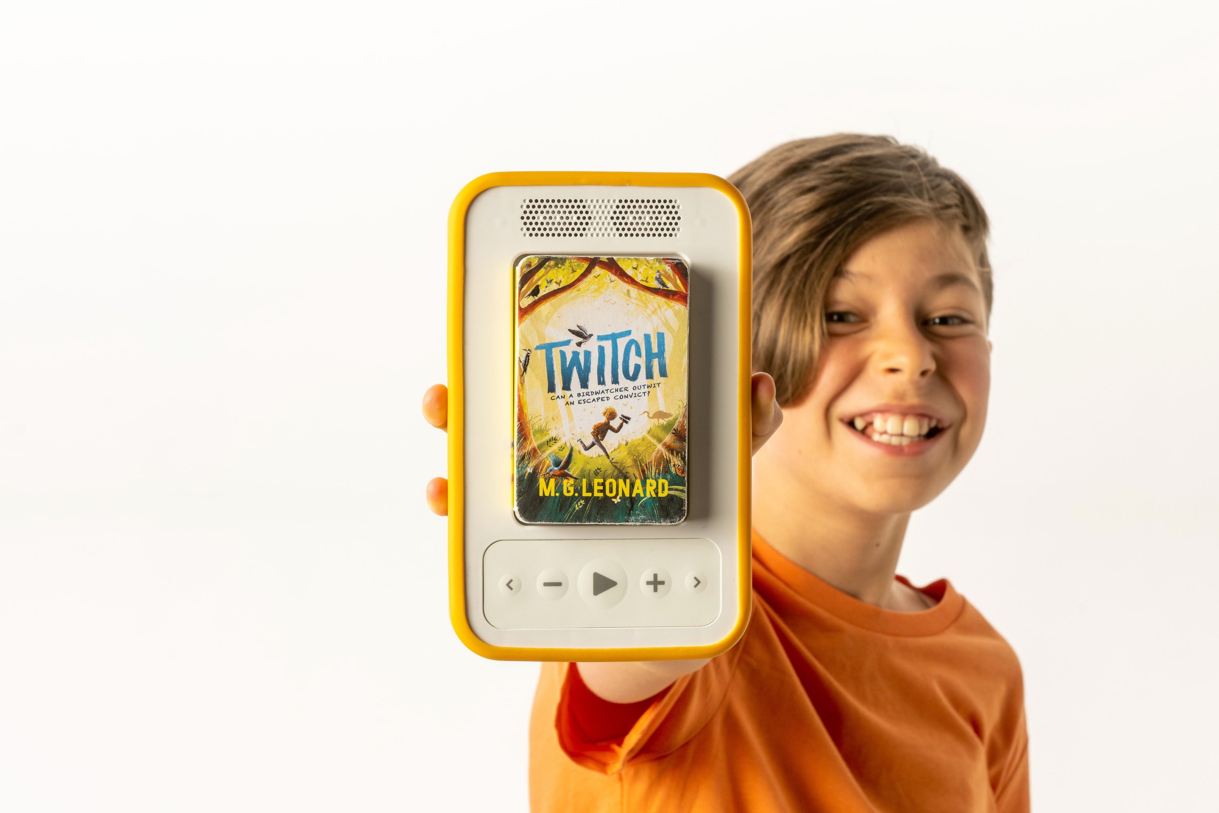 A child holds up a Voxblock audiobook player.