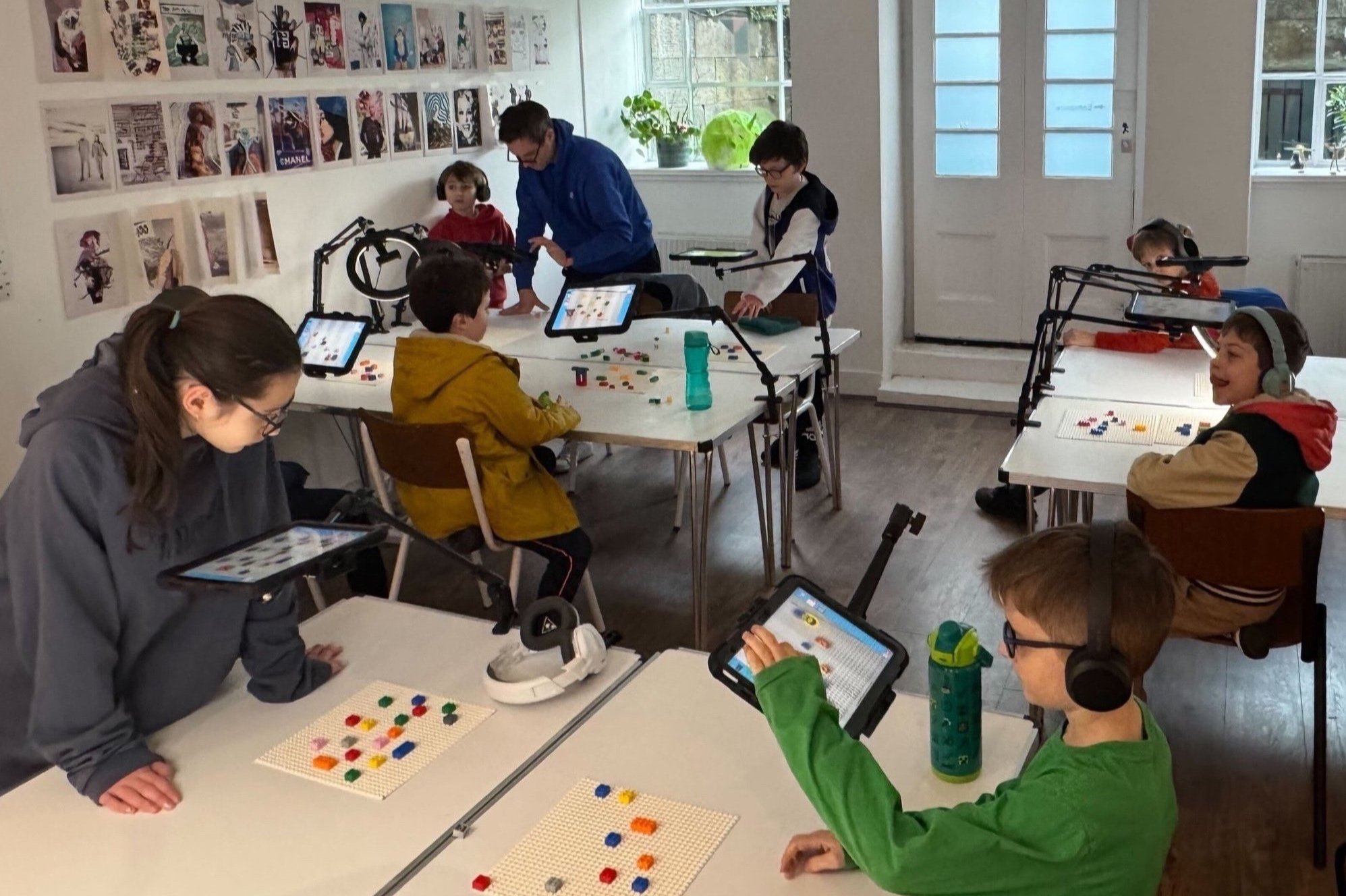 Children compose music with BeatBlocks on iPads and brick baseplates in a workshop.